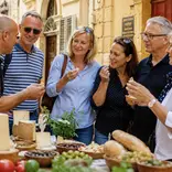Mature students attending a food tour in Valetta, Malta. Trying food from the market.