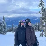 Two people smiling on a snowy mountain