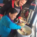 Male volunteer learns cooking skills from a Nepali woman