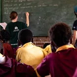 Volunteers teaching a class of students in South Africa 