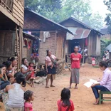 Intern working with group of women and children in Laos 