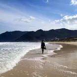 Student walking on a beach