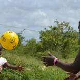 volunteer playing volleyball with children in Jamaica