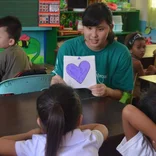 volunteer holding a sign with a heart in Philippines