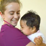 Female medical volunteer with a baby in San Jose