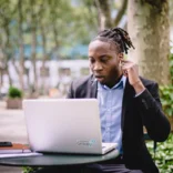 student with laptop sitting outside