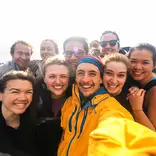 group of students smiling for a selfie on a sunny day