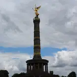 Monument in Berlin with a circular columned base and a tall tower topped with a golden angel