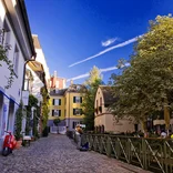 cute, quiet cobblestone street in Freiburg lined with white, yellow, and tan buildings