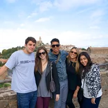 group of smiling with city skyline behind them