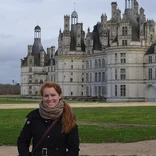 student smiling in front of a large brick chateau in Nantes