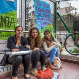 three students relaxing on a stoop in Buenos Aires