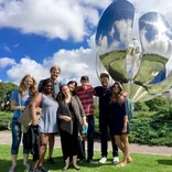 group of students standing in front of the Floralis Genérica metal sculpture in Buenos Aires
