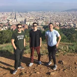 three students standing at a lookout point with the Barcelona skyline behind them