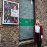 student standing by a sign for the Gaiety School of Acting in Dublin