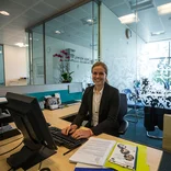 student sitting in front of a computer in an office building in London