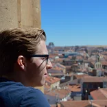 student looking out of a window at the city of Salamanca