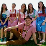 group of students in colorful lederhosen and dirndl dresses