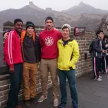 four students standing on the Great Wall of China on a foggy day