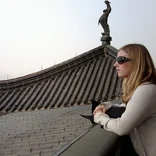 student on the rooftop of a building in Shanghai, gazing at the horizon