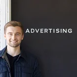 Student standing in front of an office building with a sign that says "advertising"