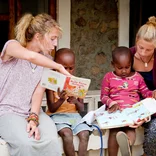 Two Projects Abroad Volunteers help local Tanzanian children learn how to read
