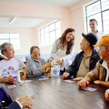 Volunteer having fun with elderly people at the project 
