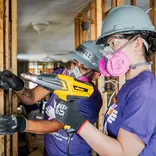 AHAH volunteers in purple shirts doing construction work on Hurricane Ian impacted home