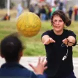 Intern throwing a netball to a student