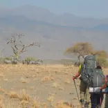 Students hike toward large mountains in the background
