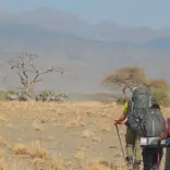 Students hike toward large mountains in the background