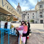 Participant holds flowers in city streets of Spain