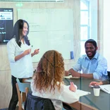 Students working on a project in a meeting room on the London campus