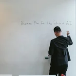 A student writing on a meeting room white board