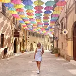 Student participant posing under umbrellas on program in Barcelona