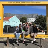 Students posing in giant frame on walking tour of Cape Town
