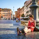 Girl studying on ground in Italy surrounded by beautiful architecture