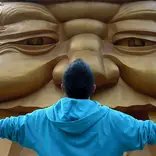 Man looking at giant statue face