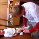 volunteer changing toddler's socks