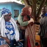 Volunteer hugging local child
