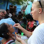 Volunteer gives a child vitamins