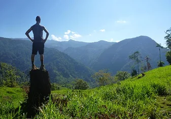 person standing on top of a tall rock