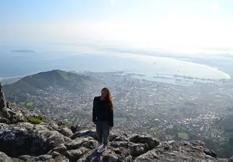 woman standing above city and coast