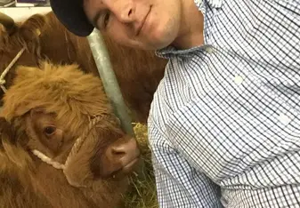 This is an image of myself and a highland cow at the Royal Highland Show