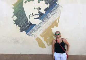 woman standing in front of mural in Cuba