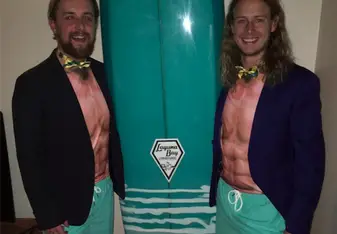 two men dressed up with surfboard