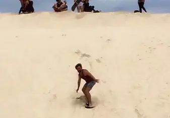 man sand boarding in desert
