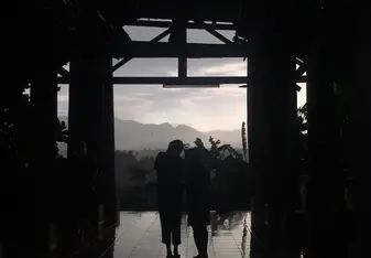 silohouette of girls overlooking mountains on balcony