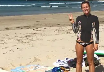 woman smiling after surfing on beach