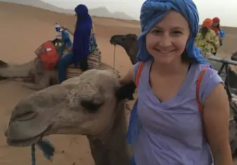 women and camels in desert